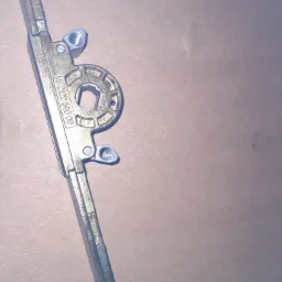 Metalowa listwa okienna z mechanizmem blokującym i numerem seryjnym 6.2122.640.00 leżąca na szarym tle.