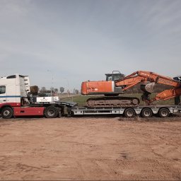 PIOTRO-TRANS Piotr Ostasiewicz - Pomarańczowa koparka Hitachi ZAXY 210 LC na niskopodwoziowej naczepie ciągniętej przez biało-czerwony ciągnik siodłowy firmy Piotro-Trans, transport sprzętu budowlanego.