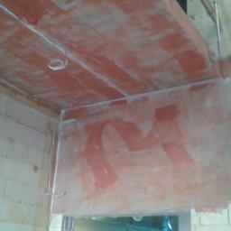 Ins-tel Maciej Romanowski - Surowy stan instalacji elektrycznej w nowym budynku: widoczne przewody poprowadzone po ścianach z pustaków i pod sufitem z terakoty, ślady po tynkowaniu.