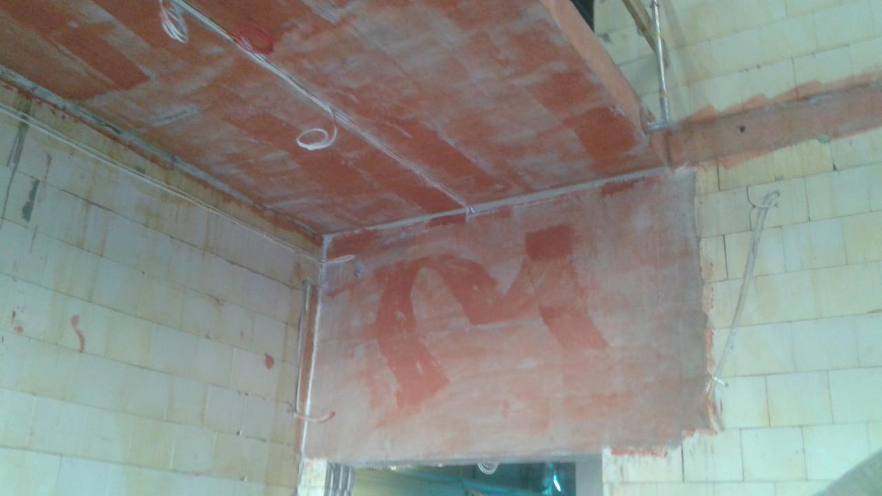 Surowy stan instalacji elektrycznej w nowym budynku: widoczne przewody poprowadzone po ścianach z pustaków i pod sufitem z terakoty, ślady po tynkowaniu.