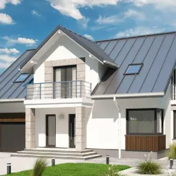 Dwukondygnacyjny dom jednorodzinny z szarą blachodachówką, balkonem z metalową balustradą i garażem z drewnianą bramą w otoczeniu zielonego trawnika i błękitnego nieba.