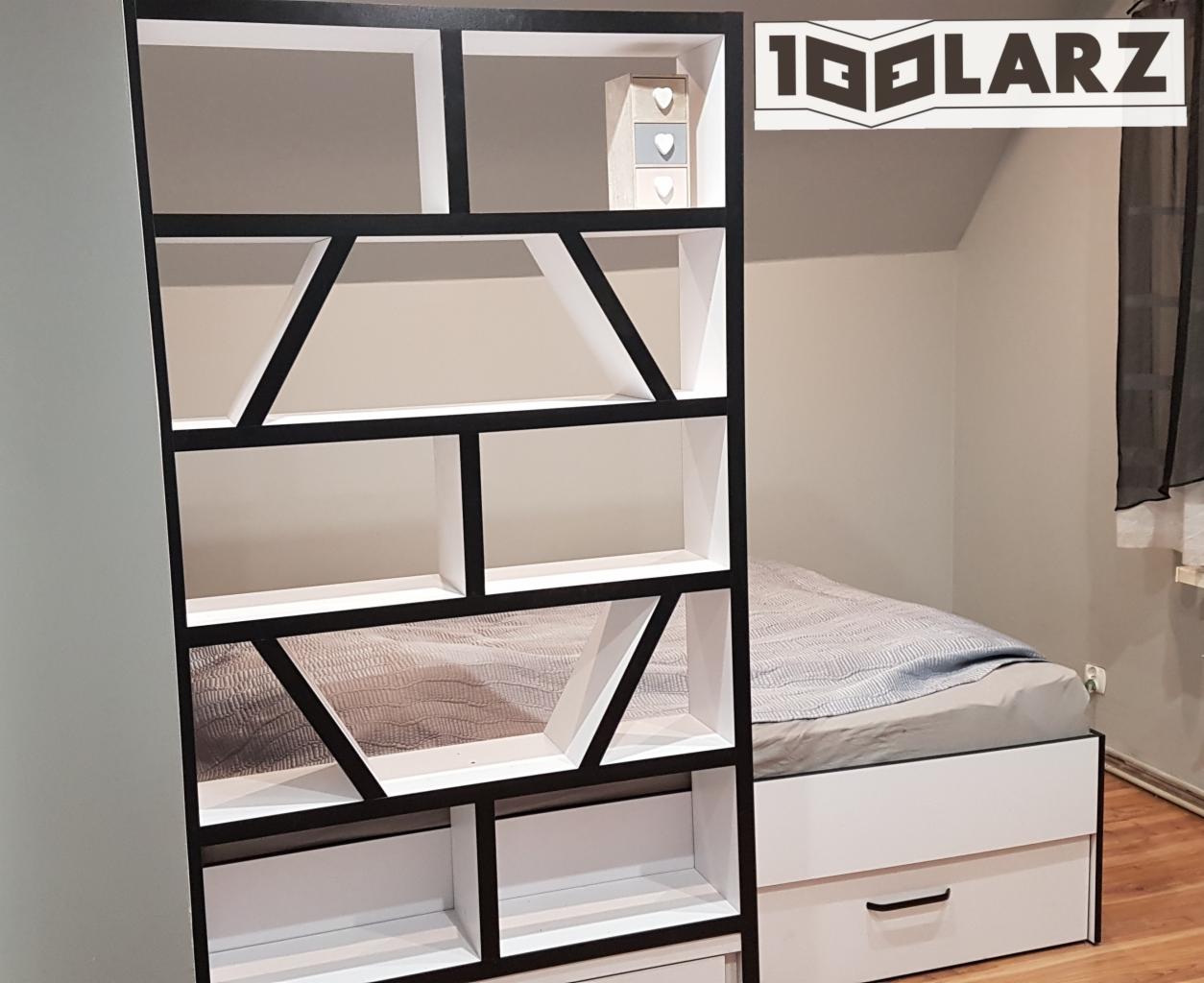 Biało-czarny regał z geometrycznymi przegródkami na tle łóżka z szufladami i logo firmy w prawym górnym rogu.