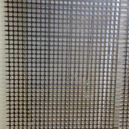 Metalowa siatka z regularnymi kwadratowymi otworami, widoczne ślady obróbki na krawędziach, surowe tło.
