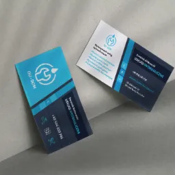 Dwie wizytówki firmy hydraulicznej OLI-DOM, z logo przedstawiającym klucz francuski i kroplę, umieszczone na szarym tle.