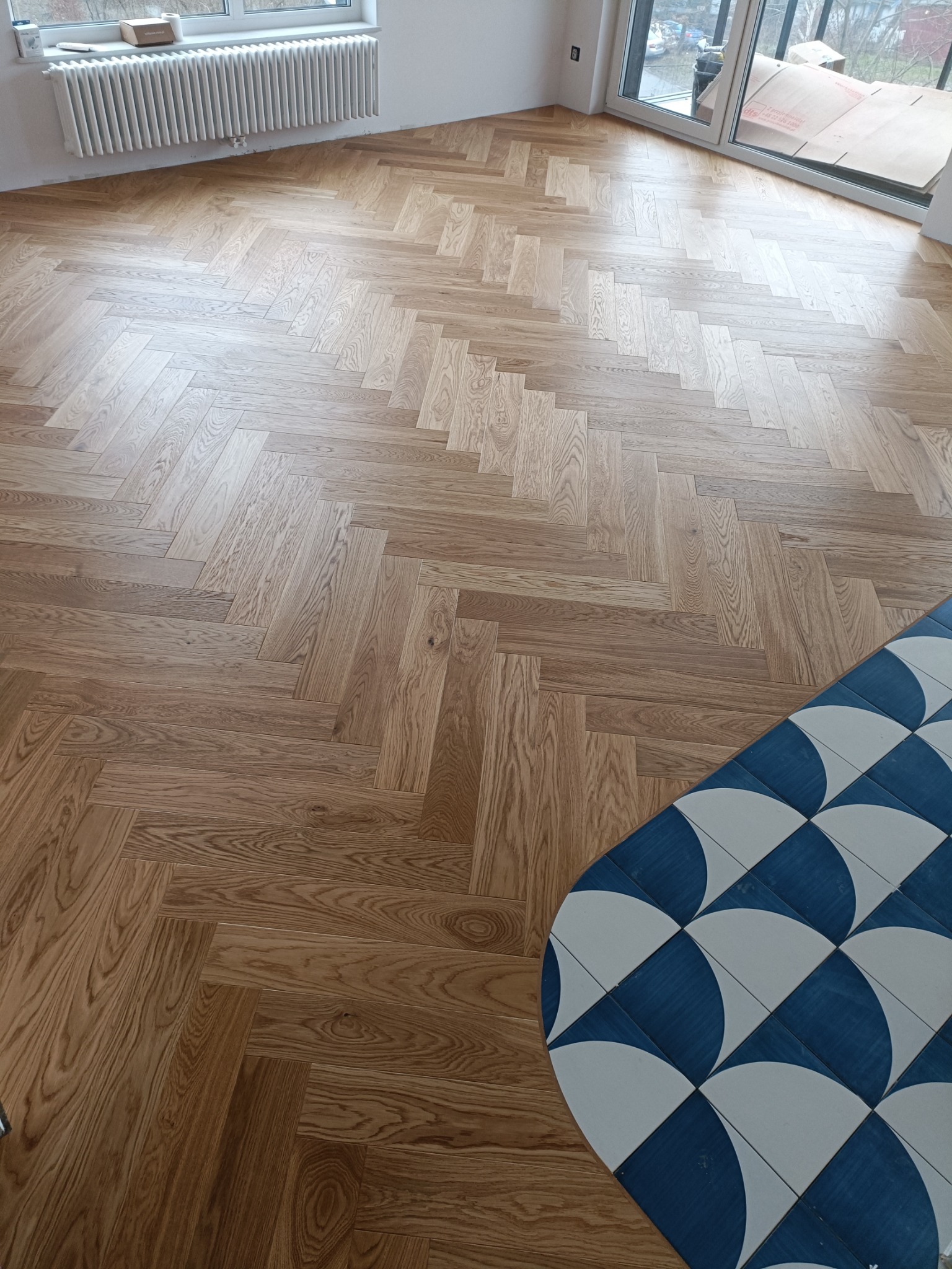 Deska podłogowa w jodełkę + cięcie kafelków po łuku CNC WaterJet. ul. Lubostroń, Kraków. Wykończenia pod klucz Kraków.