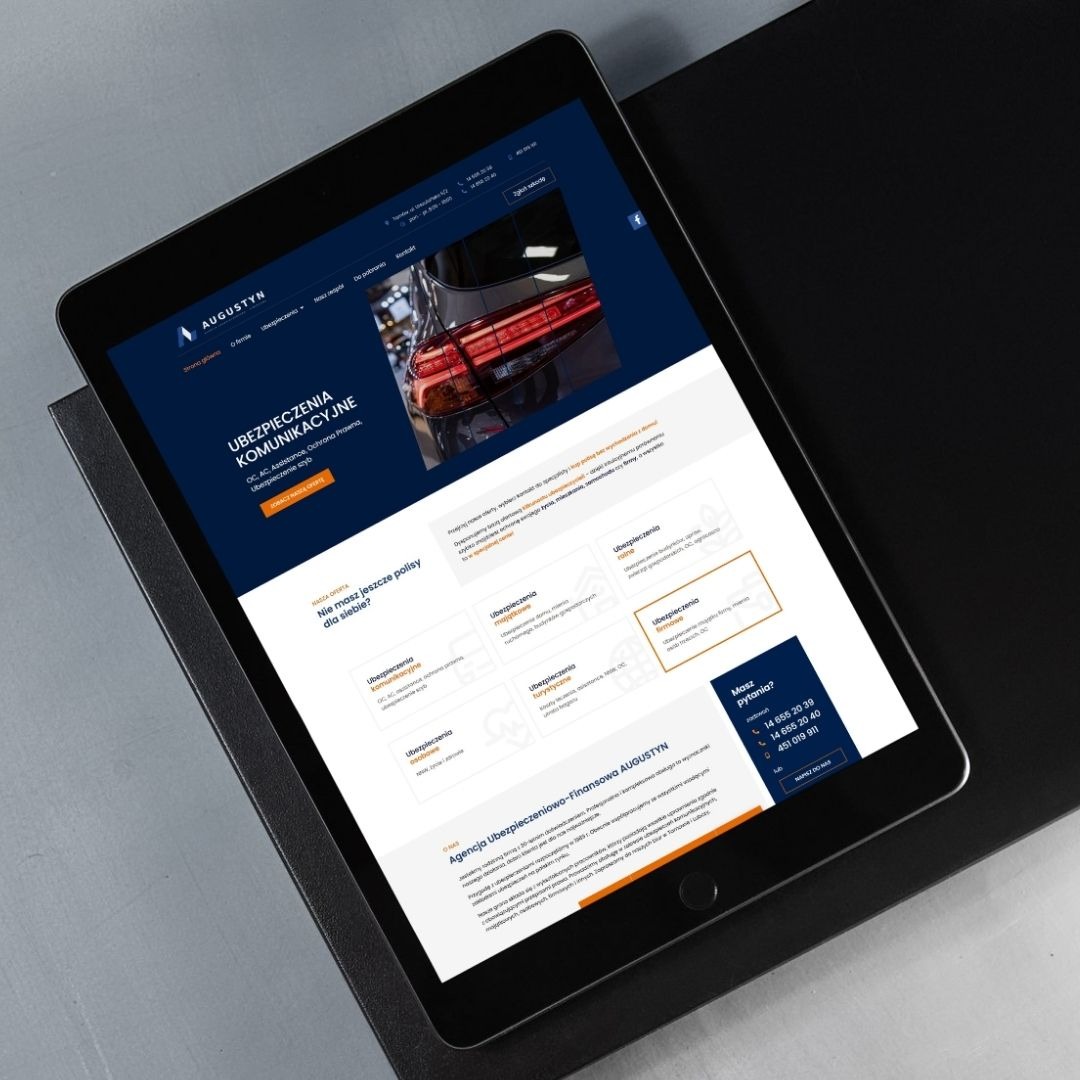Tablet prezentuje stronę internetową agencji ubezpieczeniowej Augustyn z ofertą ubezpieczeń komunikacyjnych. Widoczny fragment strony z logo, menu i zdjęciem samochodu.