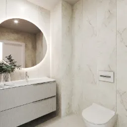 Jasna łazienka z okrągłym lustrem podświetlanym LED, umywalką nablatową, toaletą wiszącą i marmurowymi płytkami na ścianach.