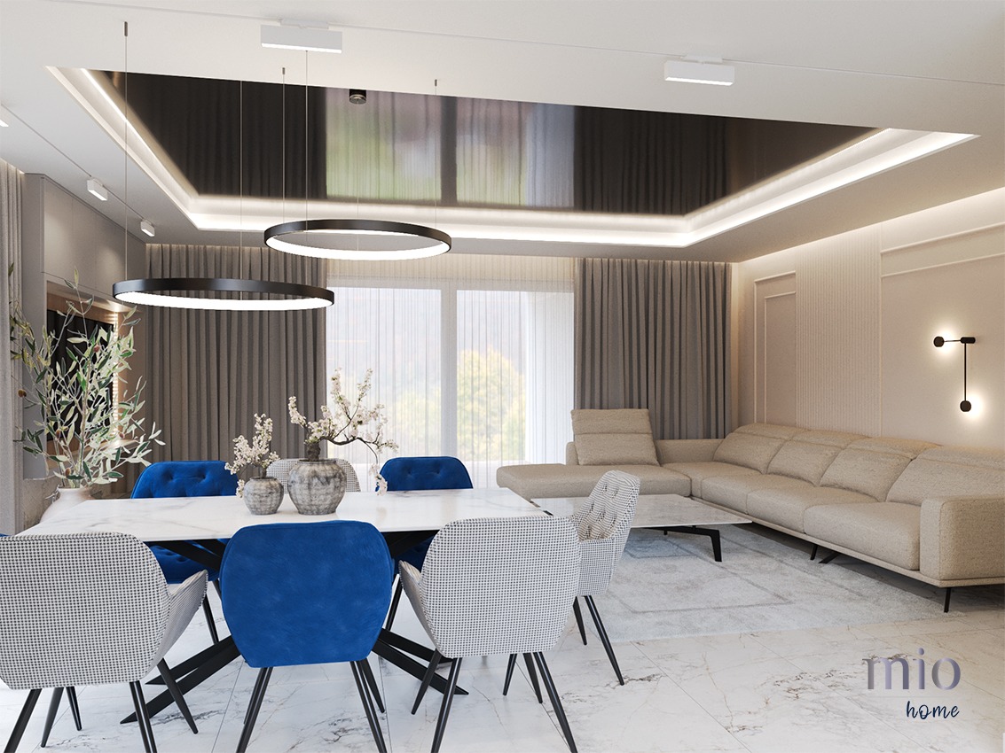 Nowoczesna jadalnia z marmurową podłogą, białym stołem i krzesłami w kolorze granatowym i szarym houndstooth, oświetlona wiszącymi lampami w kształcie pierścieni, z widokiem na salon i beżową sofę...