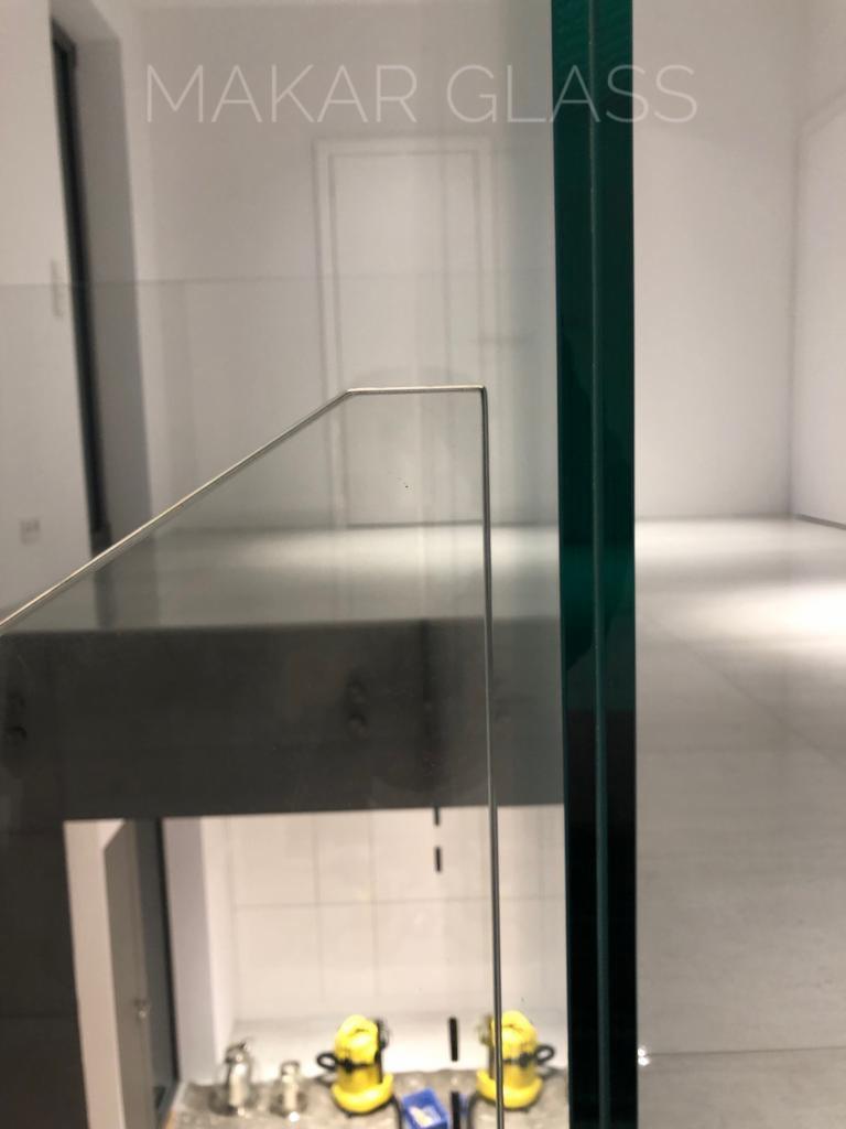 Szklana balustrada z minimalistycznym mocowaniem w Gliwicach, widok z góry na pomieszczenie ze sprzętem budowlanym i narzędziami.