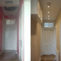 Korytarz w trakcie metamorfozy: po lewej czerwona ściana i zniszczona podłoga, po prawej świeżo wykończone ściany w odcieniach beżu i nowe oświetlenie sufitowe.