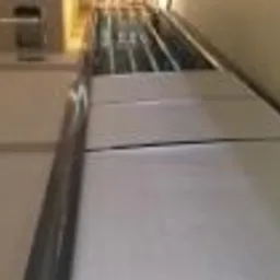 Widok z boku na białe panele chłodnicze zamontowane w pomieszczeniu, widoczne metalowe konstrukcje podtrzymujące.