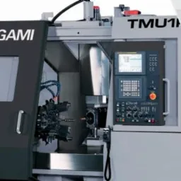 Precyzyjne maszyny do obróbki metali CNC różnych producentów, widoczne panele sterowania i głowice robocze.