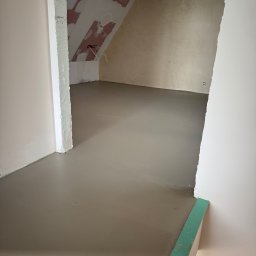 Firma ogolno budowlana Miroslaw Gros - Wylana, gładka wylewka samopoziomująca w pomieszczeniu na poddaszu. Ściany przygotowane do dalszych prac wykończeniowych. Widoczne przewody elektryczne.