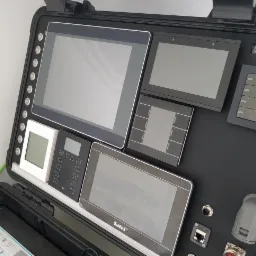 Walizka demonstracyjna z panelami sterowania systemem domu inteligentnego firmy z Bytomia, zawierająca ekrany dotykowe, przyciski i moduły Loxone.