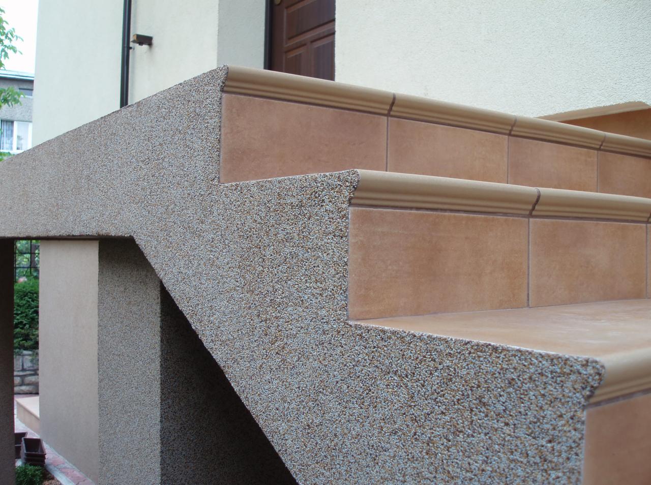 Wykończone schody zewnętrzne z terakotowymi płytkami i obłożone tynkiem mozaikowym, widok z dołu.