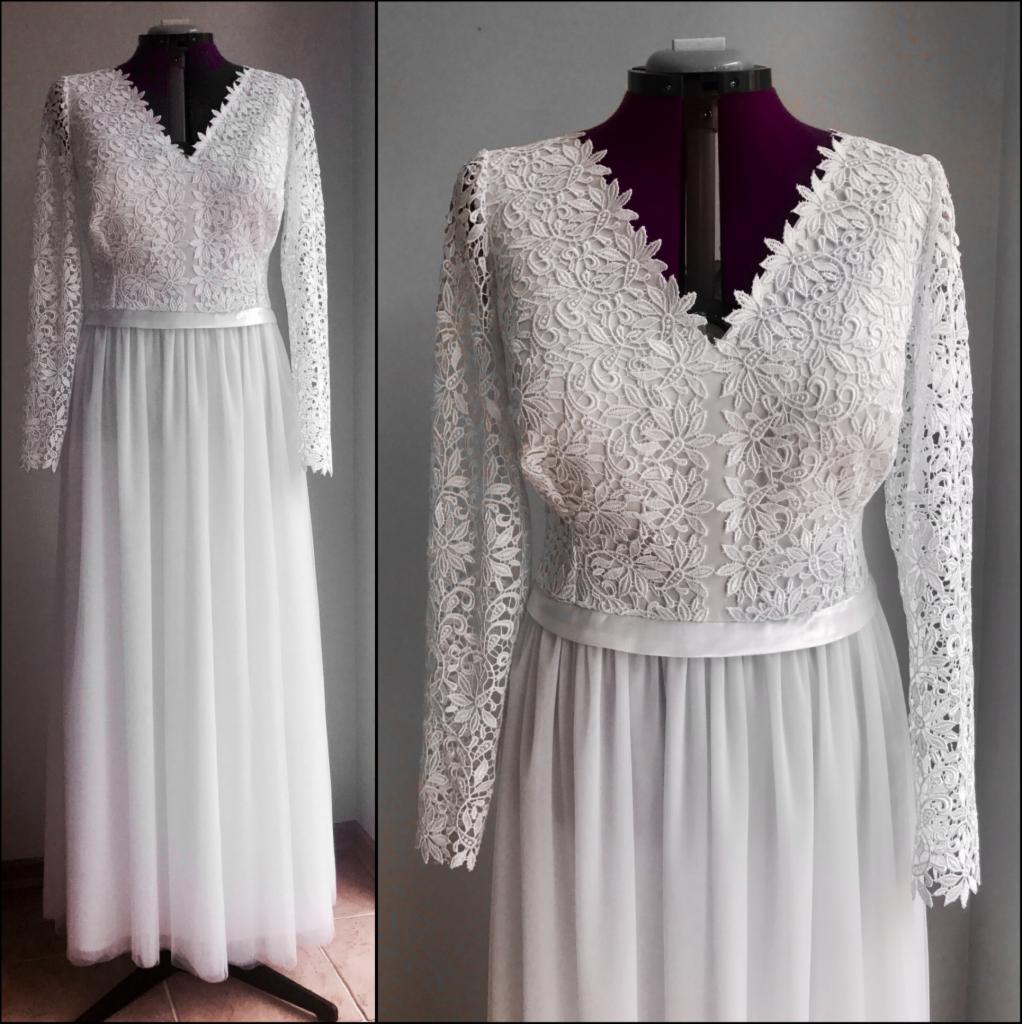 Suknia ślubna z koronkową górą i długimi rękawami, zaprezentowana na manekinie na tle szarej ściany.
