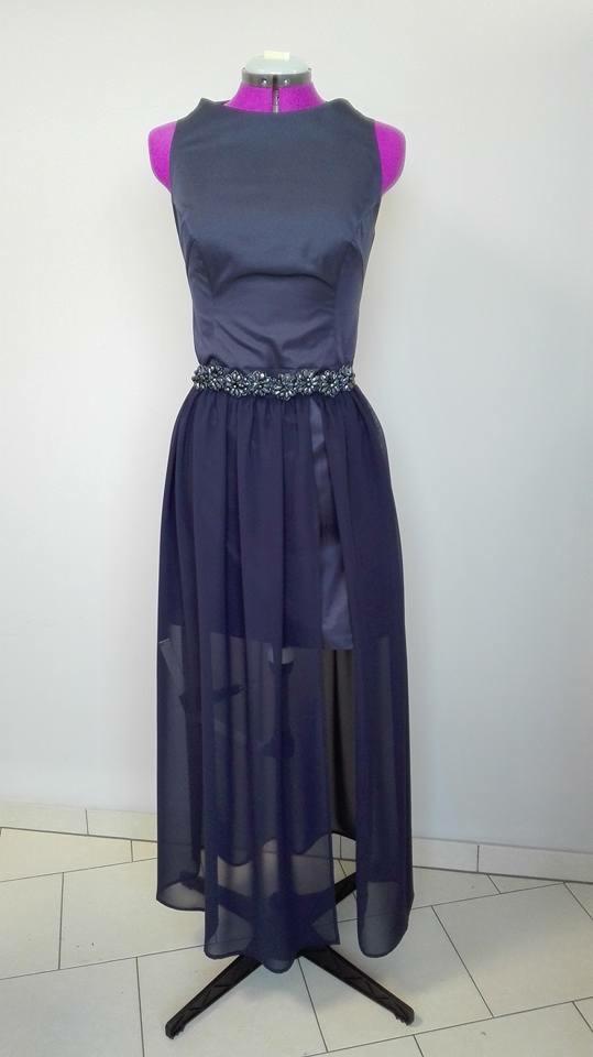 Granatowa suknia wieczorowa na manekinie krawieckim z ozdobnym paskiem z kamieni, długa, zwiewna spódnica z rozcięciem.