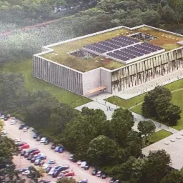 Wizualizacja budynku z zielonym dachem i panelami słonecznymi, widok z lotu ptaka, szklana fasada, parking samochodowy w tle.