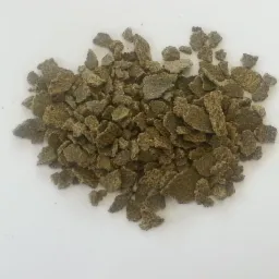 Kruszonka z brązowych, nieregularnych kawałków na białym tle, przypominająca makuchę rzepakową.