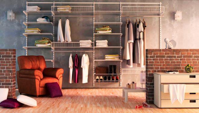 Przestronna garderoba z systemem półek i koszy, brązowy fotel z poduszkami, drewniana podłoga, ceglana ściana z komodą i dekoracyjną figurką anioła.