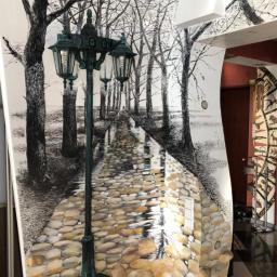 Like Denis Shapel - Iluzjonistyczne malowidło ścienne przedstawiające parkową alejkę z latarnią, wykonane w technice mieszanej: czarno-biały rysunek drzew i perspektywy alei przechodzi w trójwymiarową imitację...