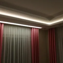 Pokój z oknami zasłoniętymi różowymi i białymi zasłonami, oświetlenie LED w suficie podwieszanym.