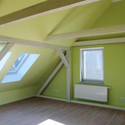 Malert - Pomalowane na jasnozielono poddasze z drewnianymi belkami pomalowanymi na biało, dwoma oknami dachowymi i dwoma zwykłymi oknami, grzejniki pod oknami, panele podłogowe