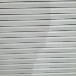 Fragment elewacji z sidingu, widoczna różnica w czystości między umytą a brudną częścią, ukazująca efekt czyszczenia.