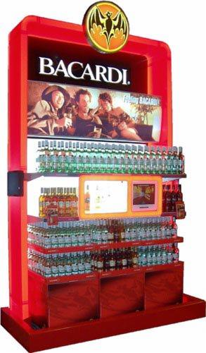 Czerwony regał sklepowy z podświetleniem, wypełniony butelkami rumu Bacardi, z reklamą marki na górze i monitorami w środkowej części ekspozycji.