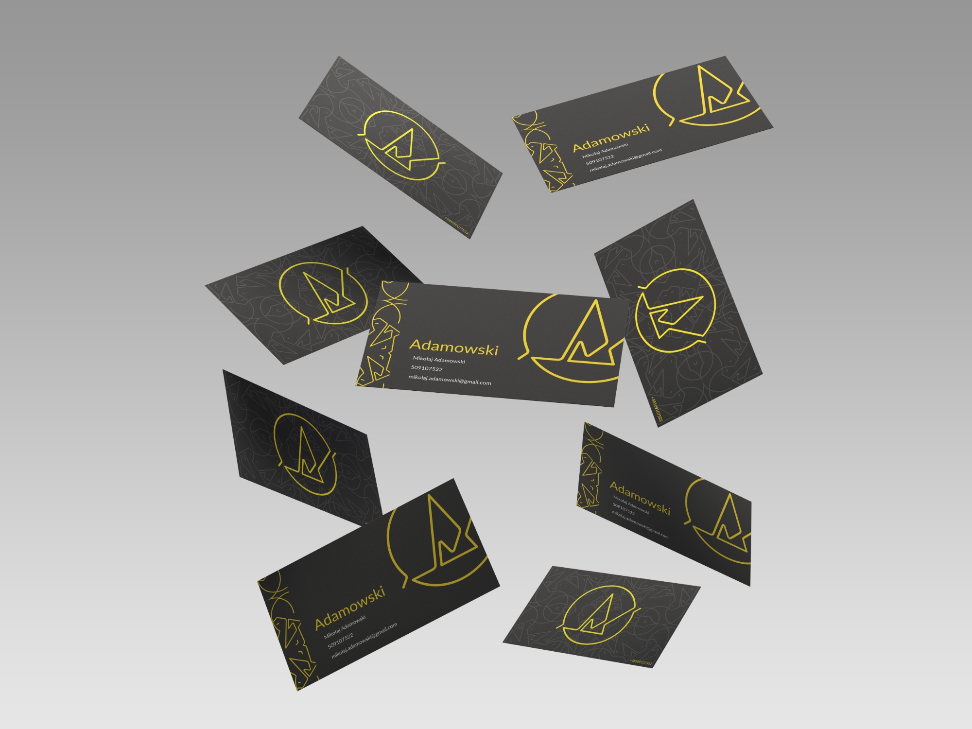 Wizytówki firmy Adamowski z czarnym tłem i złotym logo oraz danymi kontaktowymi, ułożone w przestrzeni na szarym tle.