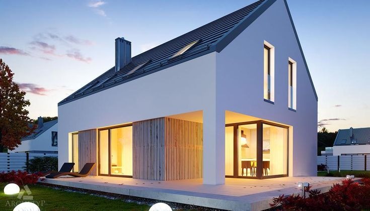 Nowoczesny dom jednorodzinny z płaskim dachem i dużymi przeszkleniami, oświetlony kulistymi lampami ogrodowymi o zmierzchu. Widoczne detale wykończenia elewacji.