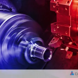 Metalowy element obrabiany na tokarce CNC, widoczne wióry i chłodziwo, oświetlenie w odcieniach czerwieni i niebieskiego.