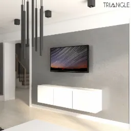 Nowoczesny salon z szarą ścianą, wiszącą szafką RTV, telewizorem wyświetlającym zdjęcie nocnego nieba, minimalistycznymi półkami ściennymi i lampami sufitowymi w kształcie tub, widok na schody w tle.