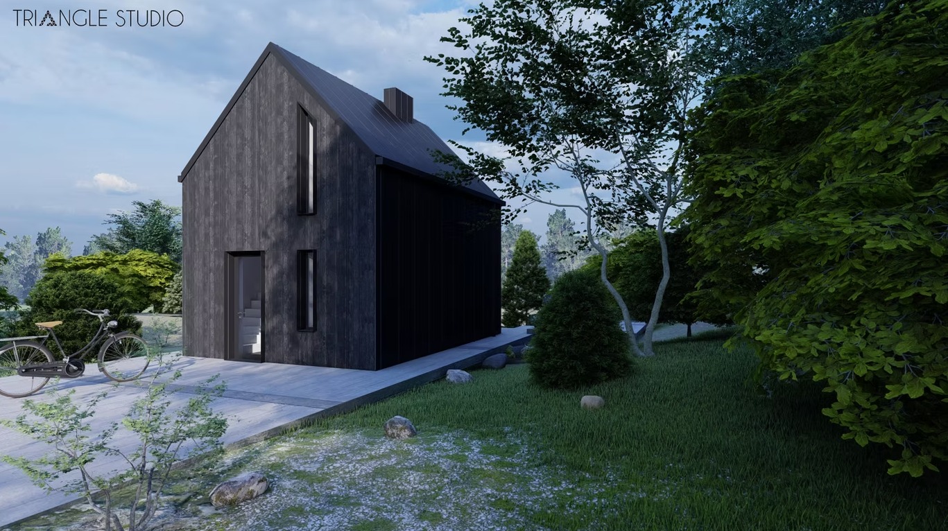 Czarny, nowoczesny dom z drewna z rowerem opartym o ścianę, otoczony zielenią. Minimalistyczna architektura z wąskimi oknami i prostą bryłą na tle błękitnego nieba.