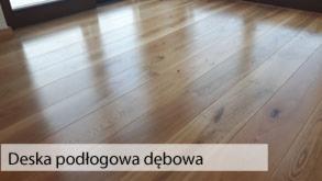 Błyszcząca, dębowa podłoga z desek, widoczna z niskiego kąta, z refleksami światła podkreślającymi naturalny rysunek drewna.