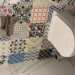 MAGGROUP Sp. z o.o. - Nowoczesna toaleta wisząca na ścianie z dekoracyjnymi, kolorowymi płytkami patchworkowymi w łazience.