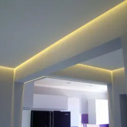 Nowoczesne oświetlenie LED wzdłuż krawędzi sufitu i przejścia między pomieszczeniami, tworzące subtelny efekt świetlny w szarej tonacji wnętrza.