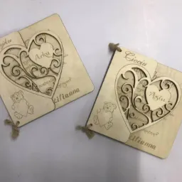 Dwa drewniane, spersonalizowane upominki z wyciętym laserowo wzorem serca, dedykowane dla wujka Arka i cioci Asi, z tekstem i motywem misia.