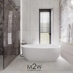 Nowoczesna łazienka z wolnostojącą białą wanną, marmurowymi płytkami na ścianach i podłodze, przeszkloną kabiną prysznicową oraz oknem z żaluzjami poziomymi.