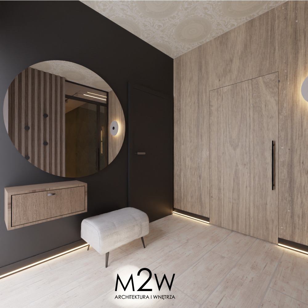 Nowoczesny przedpokój z okrągłym lustrem, wiszącą szafką na buty, pufą i ukrytym oświetleniem LED przy podłodze, w neutralnej kolorystyce.