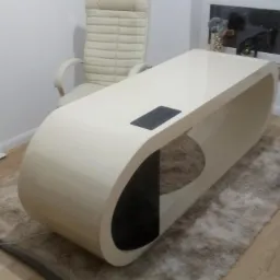 Nowoczesne biurko o zaokrąglonym kształcie z kremowego laminatu, z czarnym panelem na blacie, ustawione na puszystym dywanie w pomieszczeniu z drewnianą podłogą i krzesłem biurowym w tle.