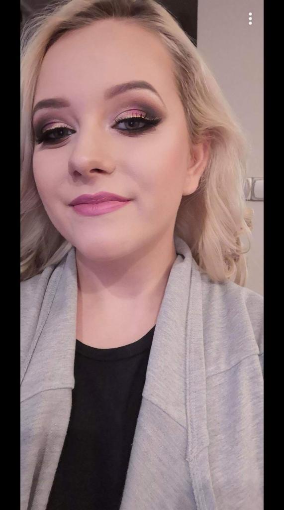 Portret kobiety z profesjonalnym makijażem oczu w odcieniach różu i brązu, oraz z pomalowanymi na różowo ustami i blond włosami.