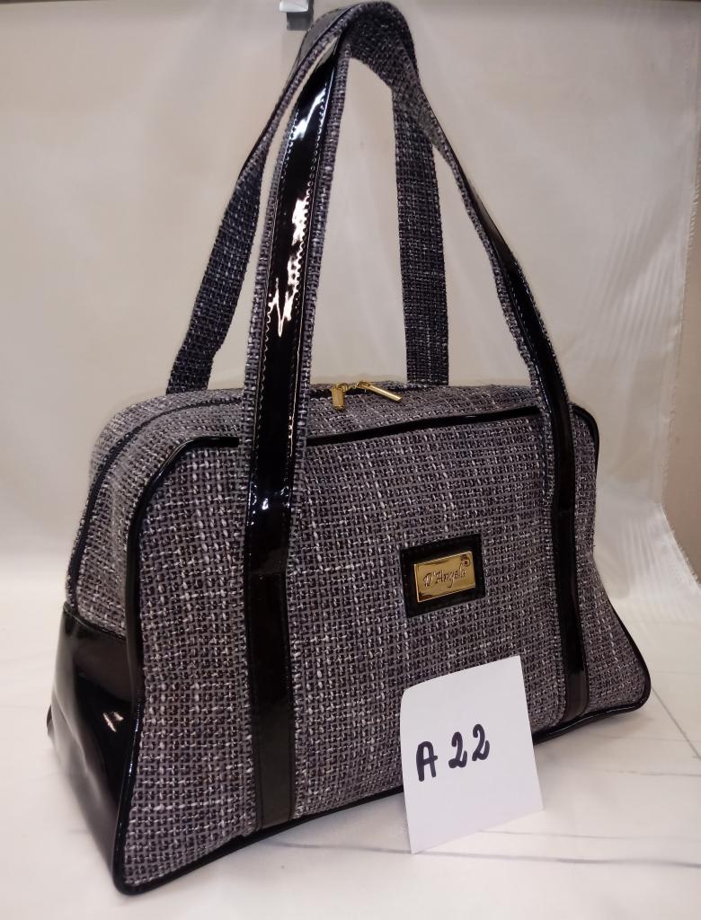 Szara torba damska z materiału przypominającego tweed, z czarnymi lakierowanymi wstawkami i uchwytami, złoty zamek błyskawiczny, etykieta z logo i kartka z napisem 'A 22'.