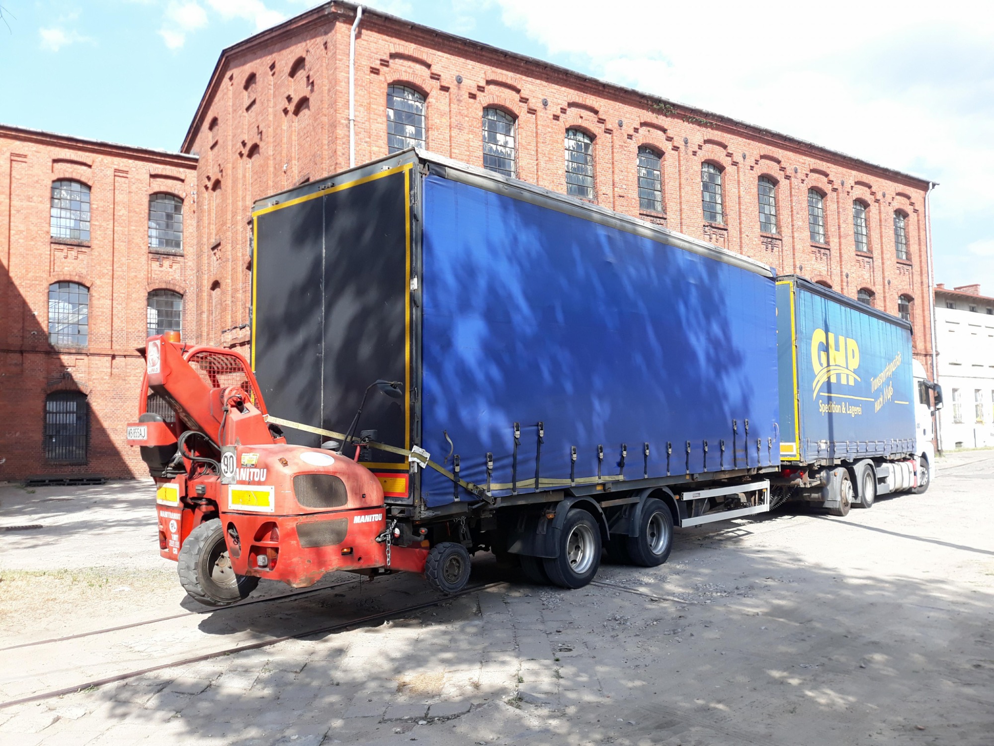 transport zestawem czyli cieżarówką z przyczepą z doczepianym wózkiem widlowym Manitou