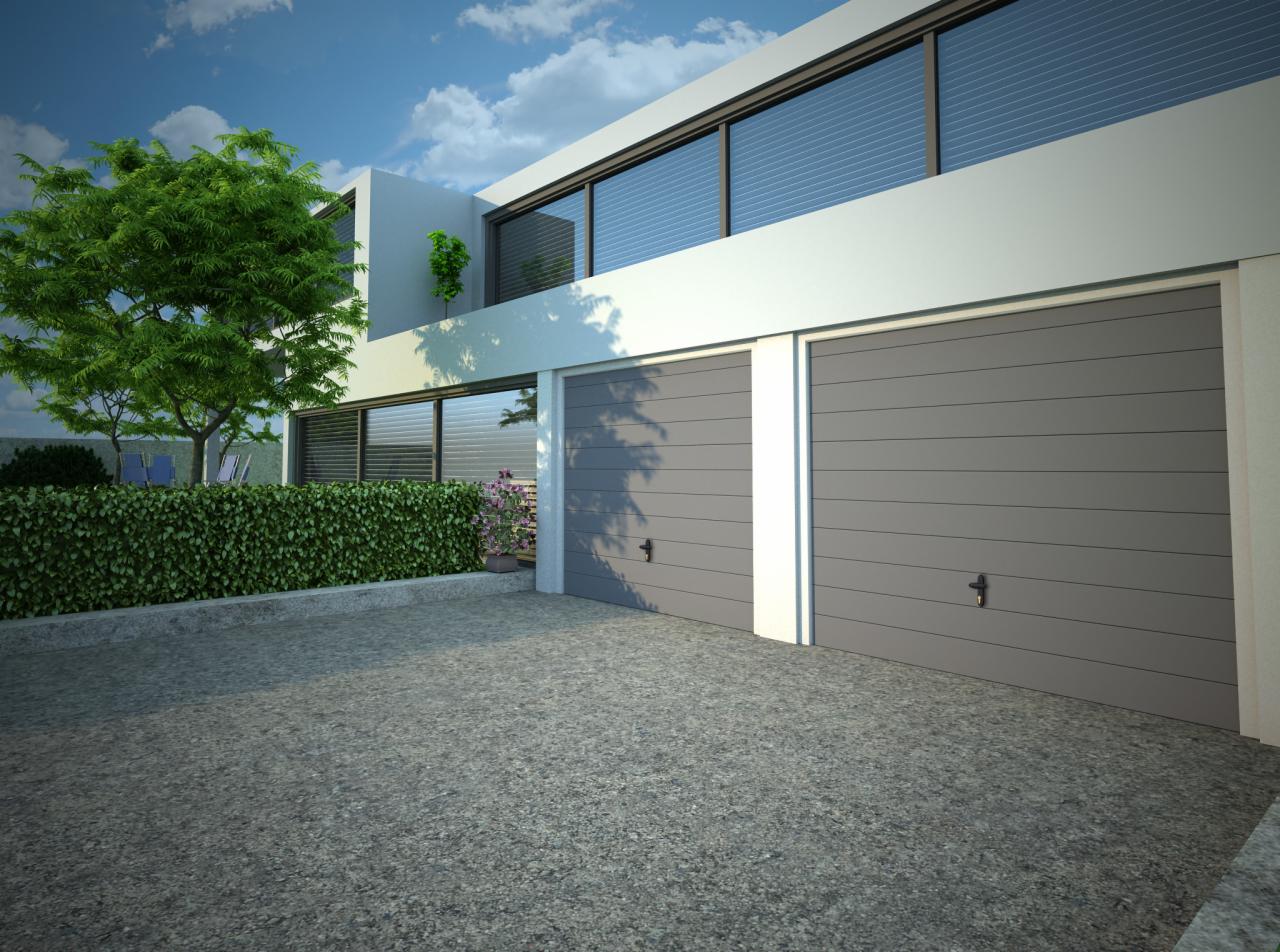 Nowoczesny dom z dwoma szarymi segmentowymi bramami garażowymi, widok z zewnątrz, zieleń w tle i na dachu.