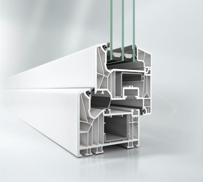 Przekrój poprzeczny białego profilu okiennego z trzema szybami, ukazujący jego wewnętrzną strukturę i komory powietrzne.