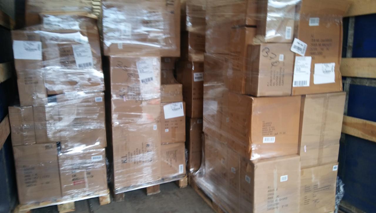 Kartonowe pudła zabezpieczone folią stretch na drewnianych paletach, załadowane w przestrzeni ładunkowej pojazdu dostawczego.