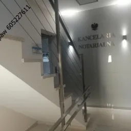 Schody w budynku Kancelarii Notarialnej z nowoczesną balustradą ze stali nierdzewnej z wypełnieniem linkami stalowymi.