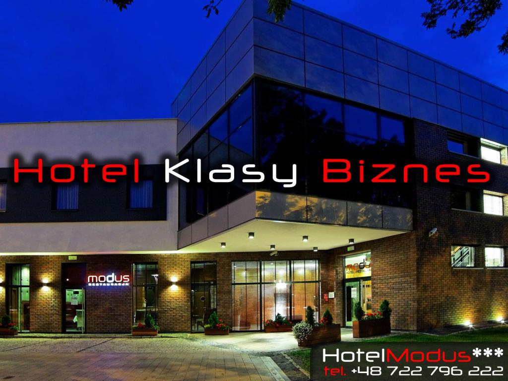 Elewacja hotelu klasy biznes z przeszkloną fasadą i oświetlonym wejściem, widok nocny.