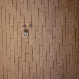 Tekstura ściany imitująca cegłę, widoczne gniazdka elektryczne, oświetlenie punktowe.